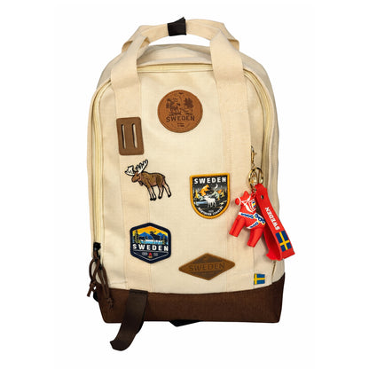 Nyckelring hängande, bestående av en röd PVC rem med svensk flagga, texten "Sweden", en dalahästfigur och en guldfärgad nyckelring. Visas här hängandes på våran ryggsäck Sweden beige.