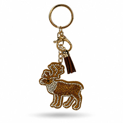 En brun ren formad nyckelring dekorerad med glittrande strass i guld och silver. Nyckelringen har en brun tofs samt en guldfärgad karbinhake och ring.