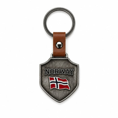 Nyckelring i metall som hänger i ett brunt läderband med metallring. Nyckelringen är sköld formad och pryds av texten "Norway" och norska flaggan.