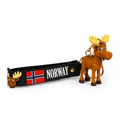 Nyckelring med en söt älgfigur fäst vid guldfärgad ring och svart PVC rem. Remmen pryds av norsk flagga, älghuvud och texten "Norway". Sedd från sidan.