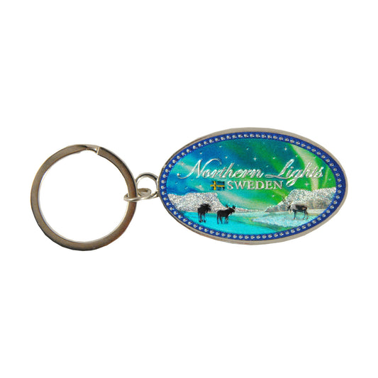 Oval metallnyckelring med texten "Sweden" och motiv av norrsken över Lapporten i folie.







