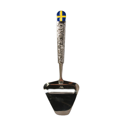 Andra sidan av osthyveln med en svensk flagga och ett fint mönster i metallen på skaftet. 
