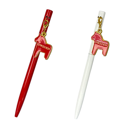 Två pennor med dalahästberlock – en röd och en vit – med texten "Sweden" i guldfärg.

