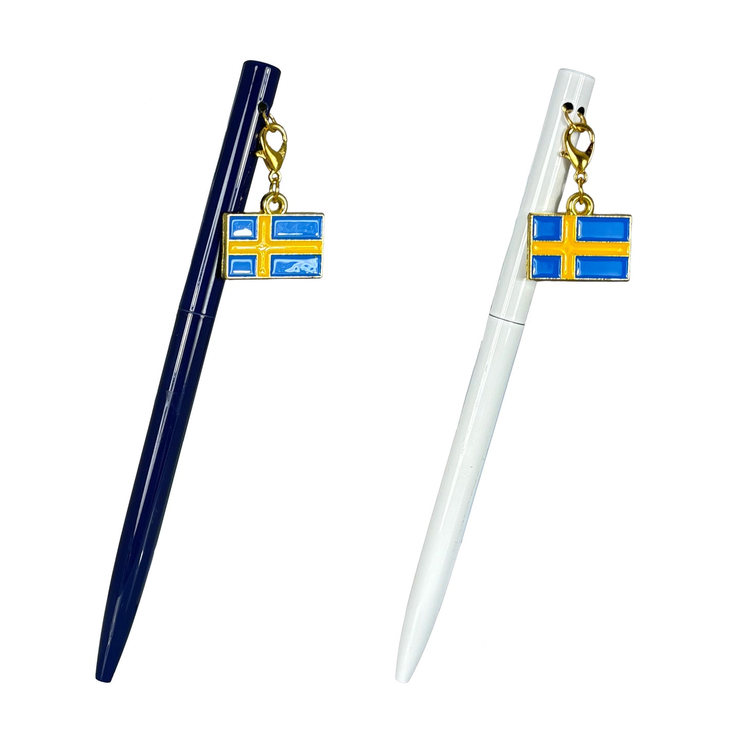 Två pennor med berlock i form av svenska flaggan – en vit och en mörkblå.

