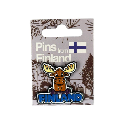 Pin monterad på grå hängetikett med skogsmotiv, finsk flagga +  texten "Pins from Finland" – redo för butiksexponering.