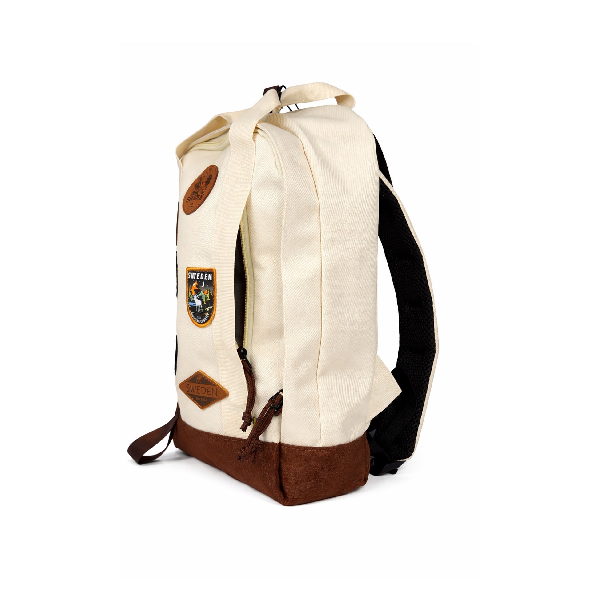 Beige ryggsäck med brun botten och snören. Läder och broderade märken med en älg och texten SWEDEN. Visas här snett framifrån med lilla fram facket öppet.