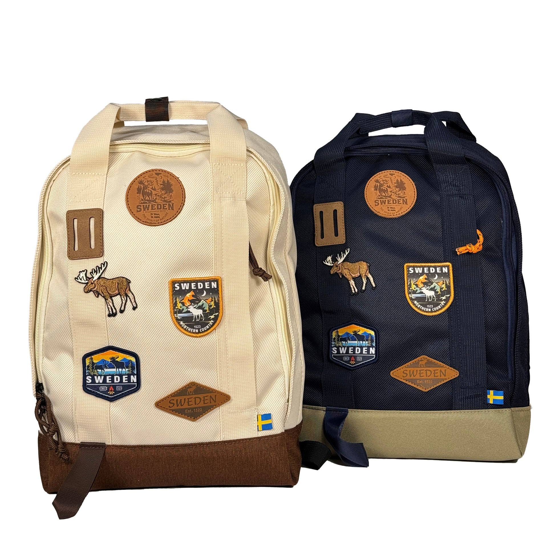 Blå och beige ryggsäck med läder och broderade märken med en älg och texten SWEDEN. 