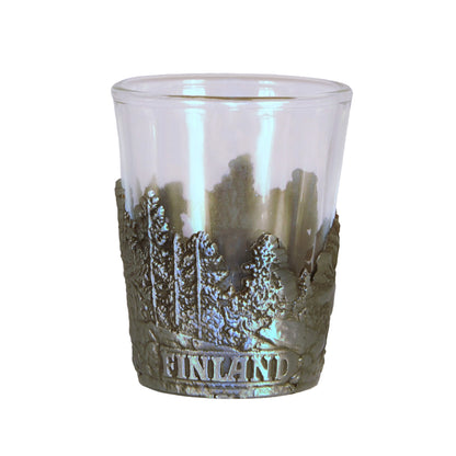 Shotsglas i glas med ett omslag i tennfärgad metall med skogsmotiv och texten Finland.