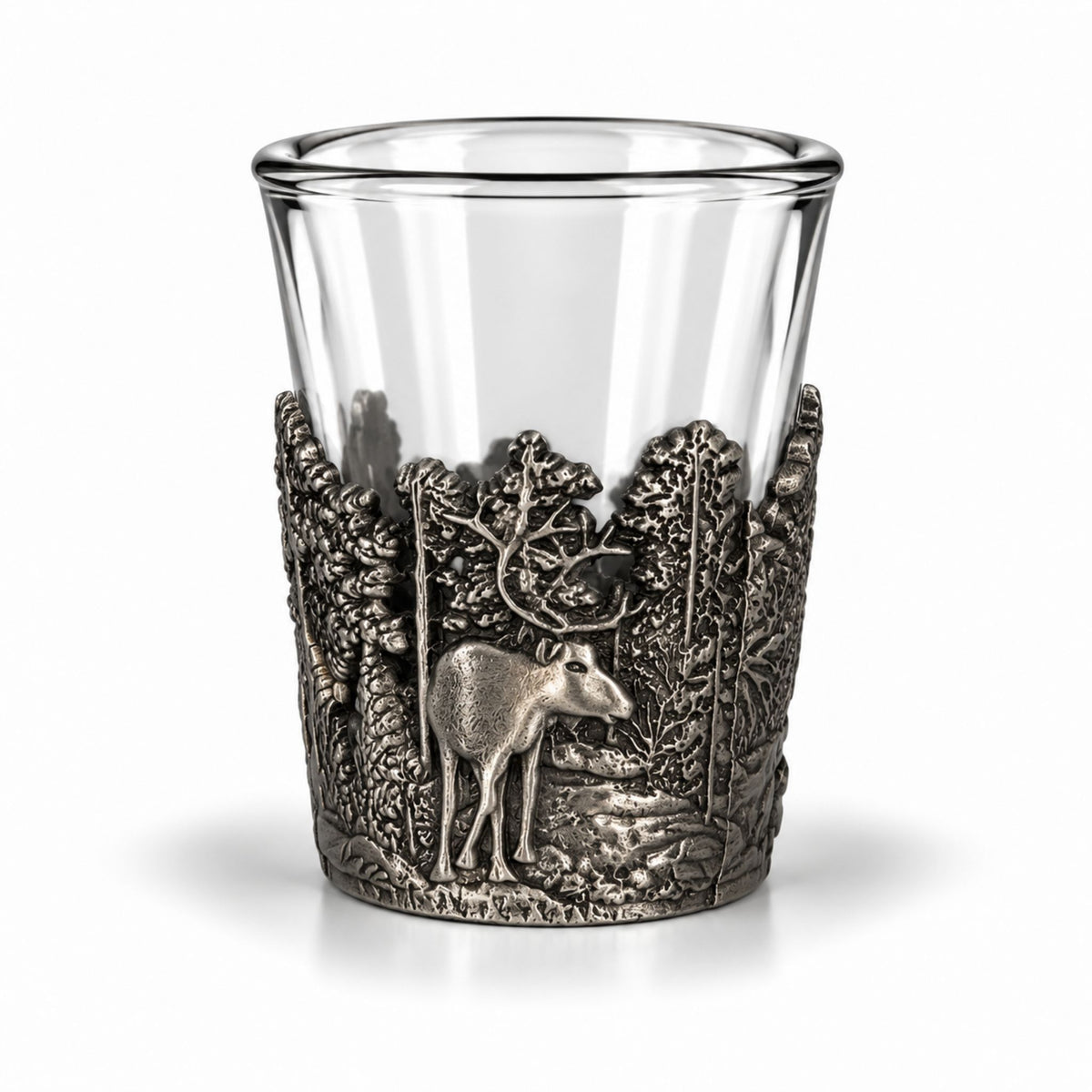 Shotsglas i glas med ett omslag i tennfärgad metall fotat ur ytterliga en annan vinkel, här visas glasets skogsmotiv med en ren sedd framifrån.