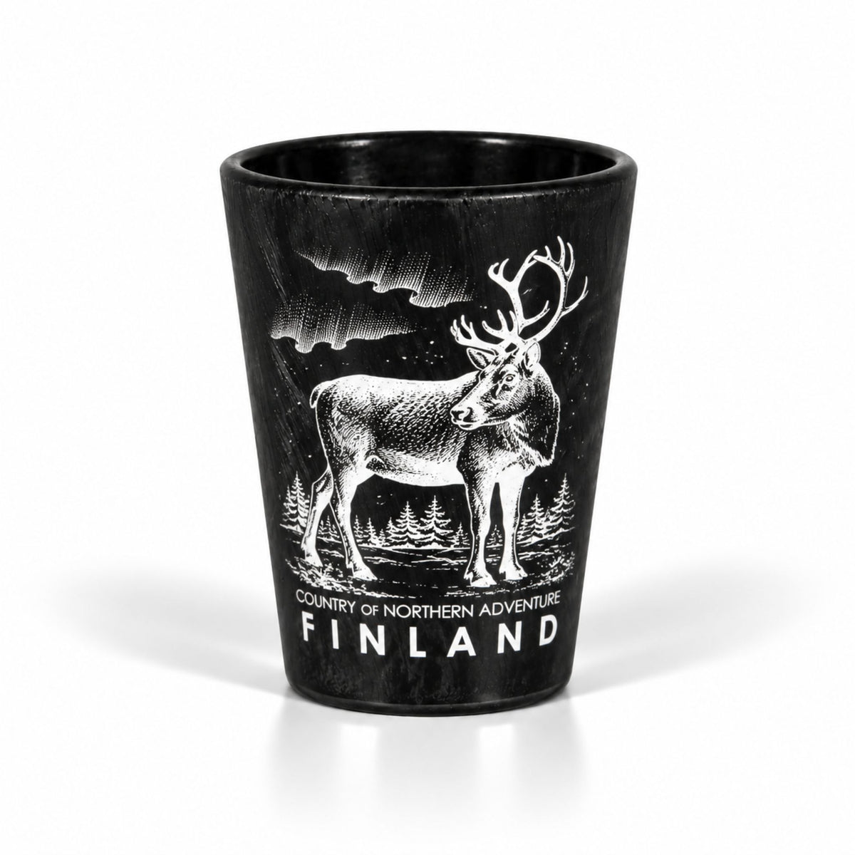Svart shotglas med en isliknande yta och motiv av en ren samt texten "Finland – Country of northern adventure".