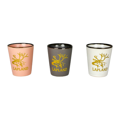 Tre shotglas i rosa, vitt och grått med guldfärgat renhuvud och texten "Lapland".