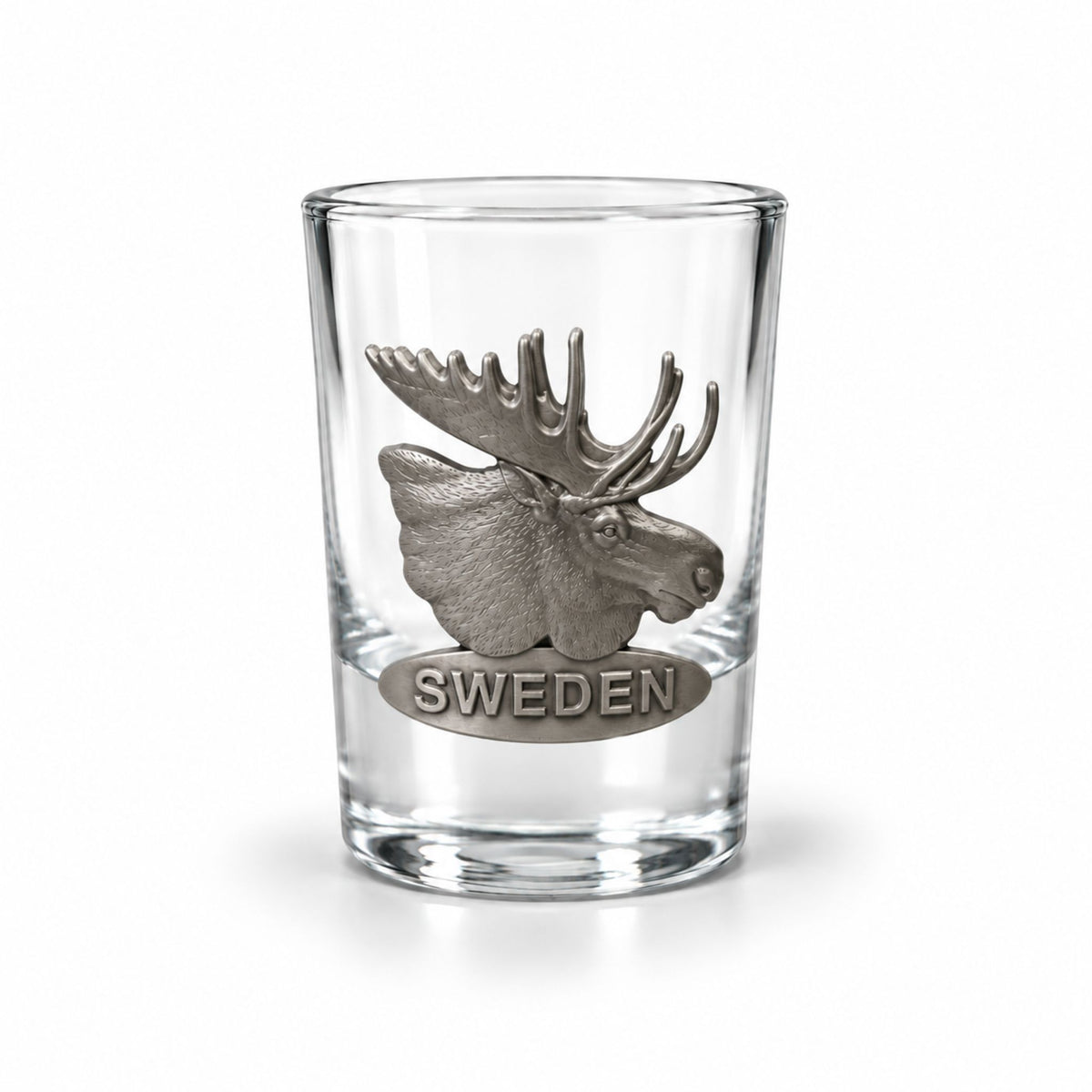 Stilrent shotglas prytt med ett metallmärke i form av en älg och texten "Sweden".