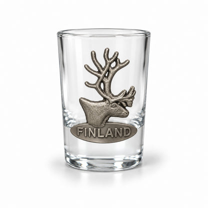 Shotglas prytt med ett metallmärke i form av en ren och texten "Finland".