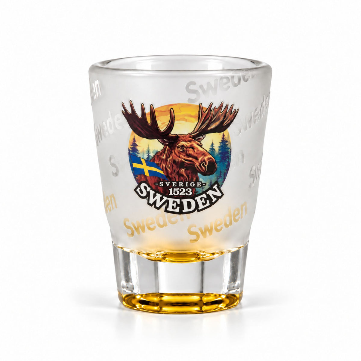 Frostat shotglas med gul botten, motiv av ett ståtligt älghuvud och texten "Sweden" flera gånger runt glaset.