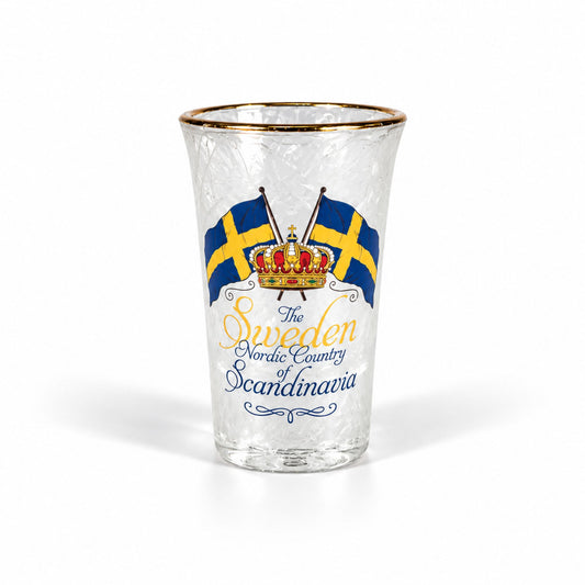 Frostat shotglas med guldkant, två korsade blågula flaggor, en krona och texten "Sweden – The Nordic Country of Scandinavia". Ett stilrent glas med kall och fräsch look.