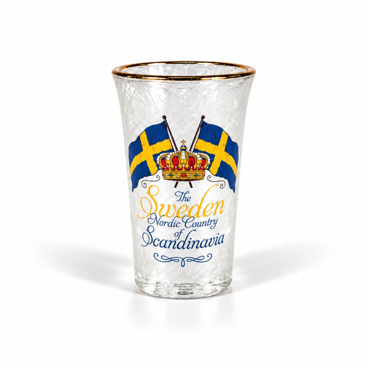 Frostat shotglas med guldkant, två korsade blågula flaggor, en krona och texten "Sweden – The Nordic Country of Scandinavia". Ett stilrent glas med kall och fräsch look.