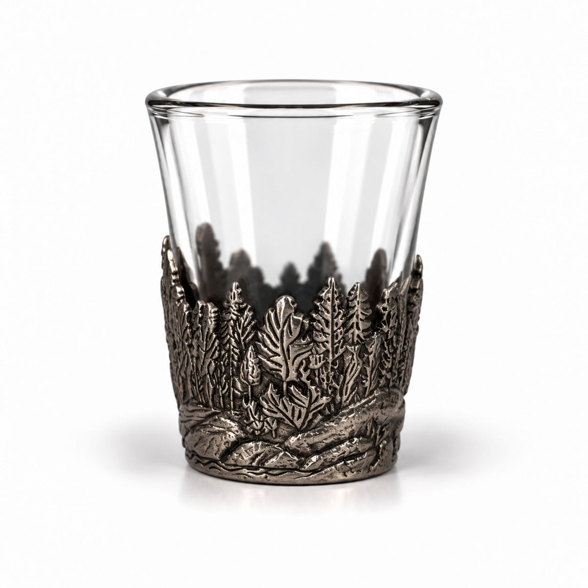 Shotsglas i glas med ett omslag i tennfärgad metall med skogsmotiv. 