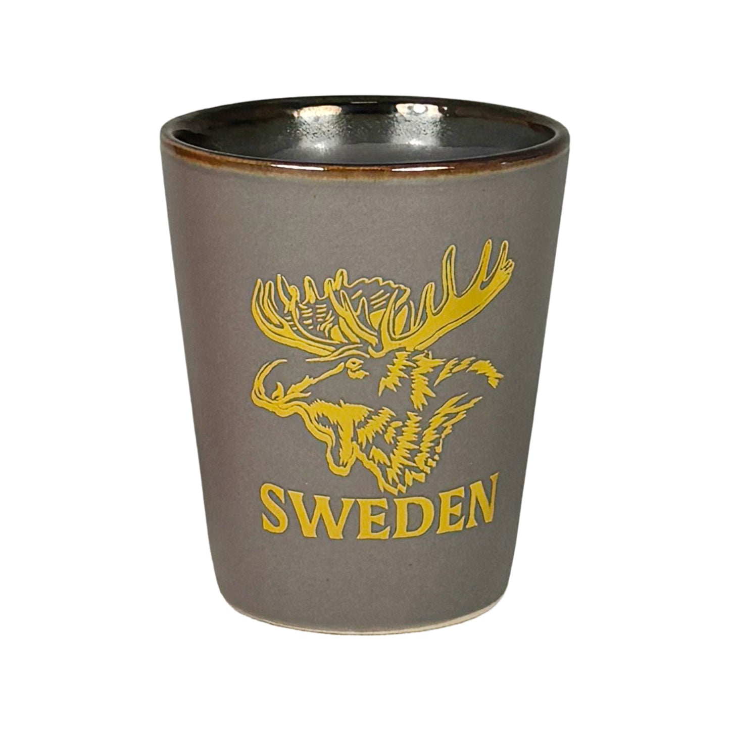 Grått shotglas med guldfärgat älghuvud och texten "Sweden".
