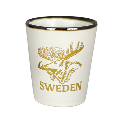 Vitt shotglas med guldfärgat älghuvud och texten "Sweden".