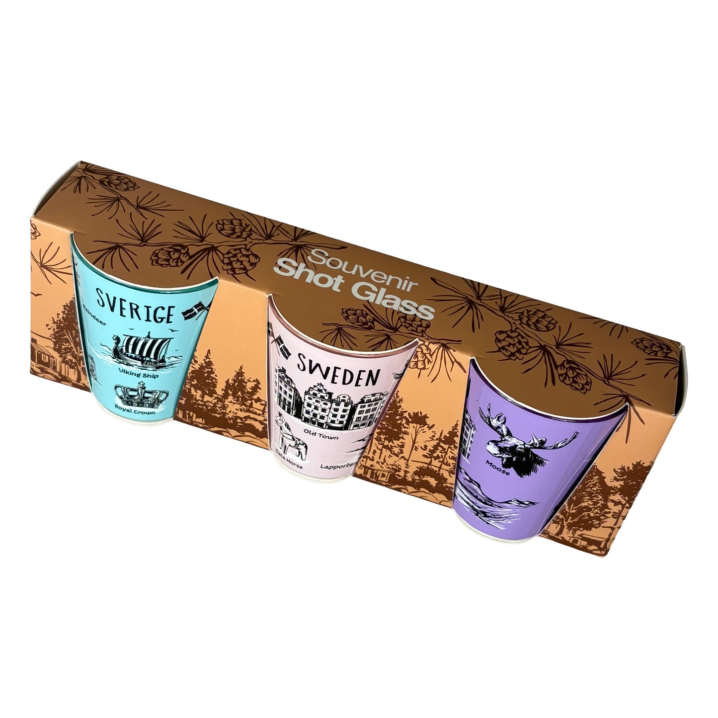 Shotglas 3-pack i förpackning, sett snett ovanifrån med lila, rosa och ljusblå glas synliga. Förpackningen är i brun papp, med mörkbrunt skogsmotiv och texten Souvenir Shot Glass i vitt. 