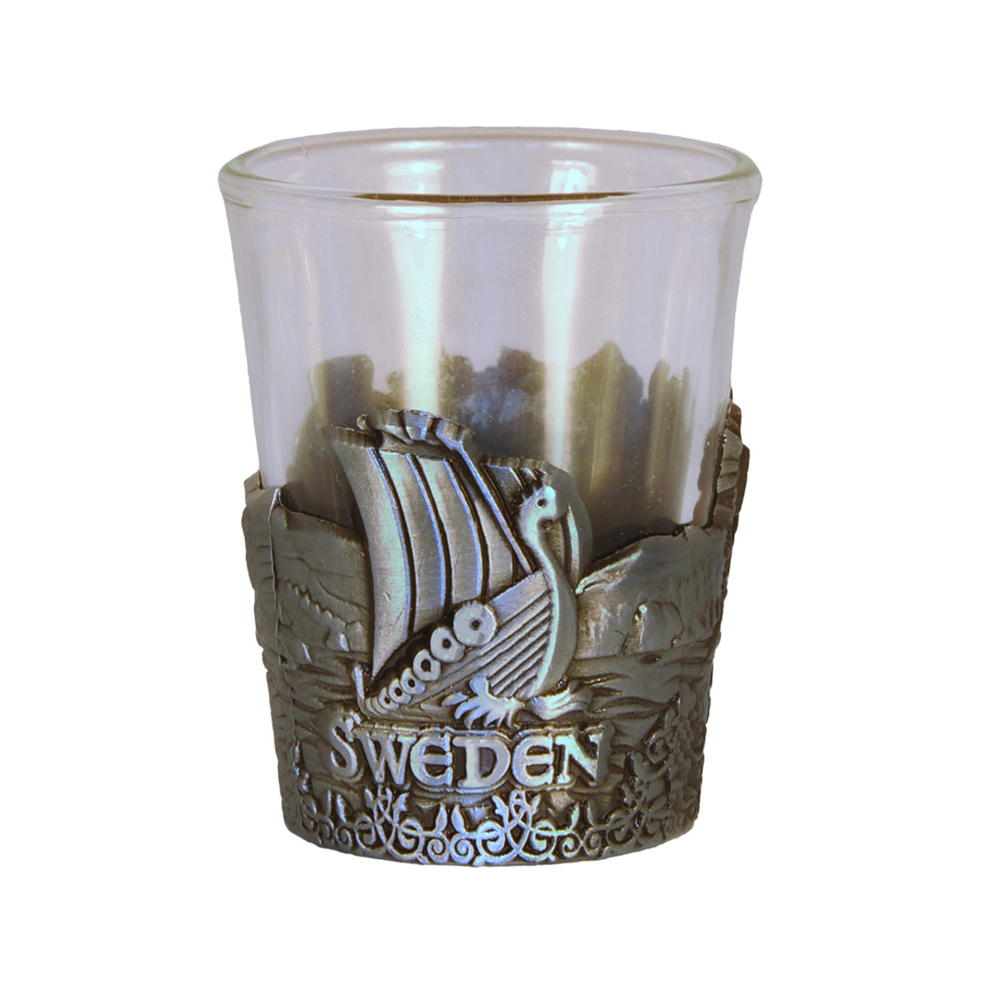 Shotsglas i glas med ett omslag i tennfärgad metall med vikingamotiv. Här syns ett vikingaskepp och texten Sweden. 