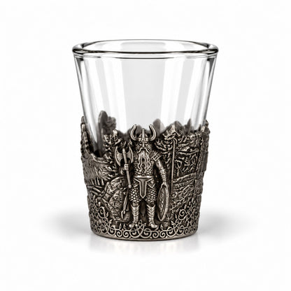 Shotsglas i glas med ett omslag i tennfärgad metall med vikingamotiv. Här syns en viking. 