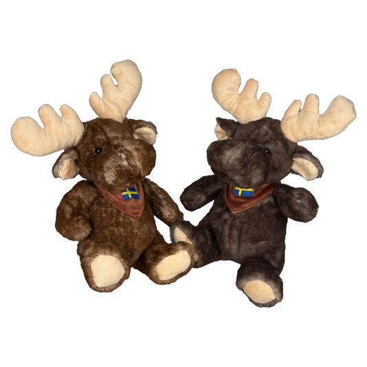 Två gosedjursälgar, en ljusbrun och en mörkbrun, iklädda bruna halsdukar med svenska flaggan.