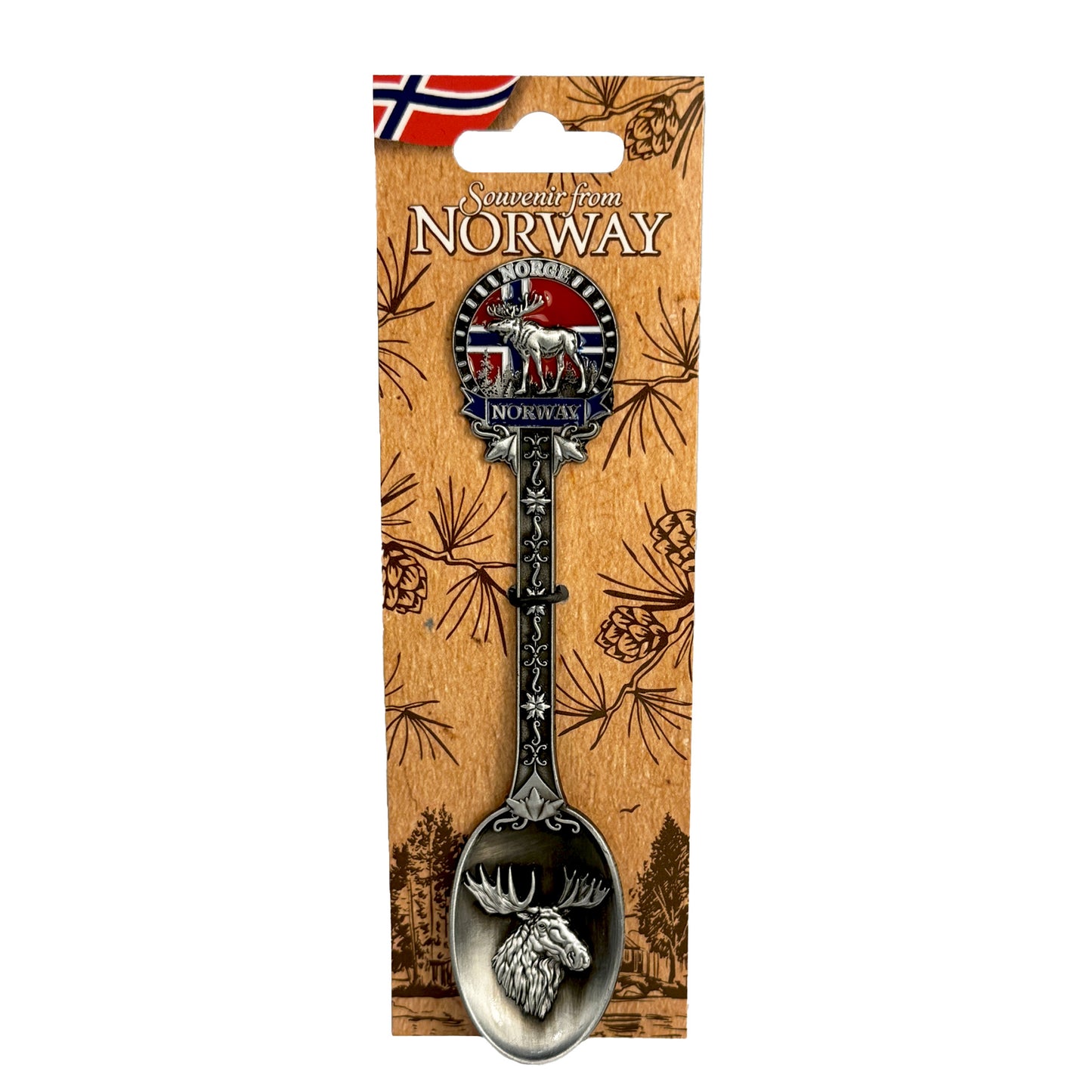 Silverfärgad souvenirsked med ett älghuvud i skedens kupa. Skaftet är dekorerat med ett fint mönster, en älg, norska flaggan samt texten "Norge" och "Norway". Visas här på ljusbrun hängetikett prydd med ett mörkbrunt skogsmotiv, norska flagga och texten "Souvenir from Norway".