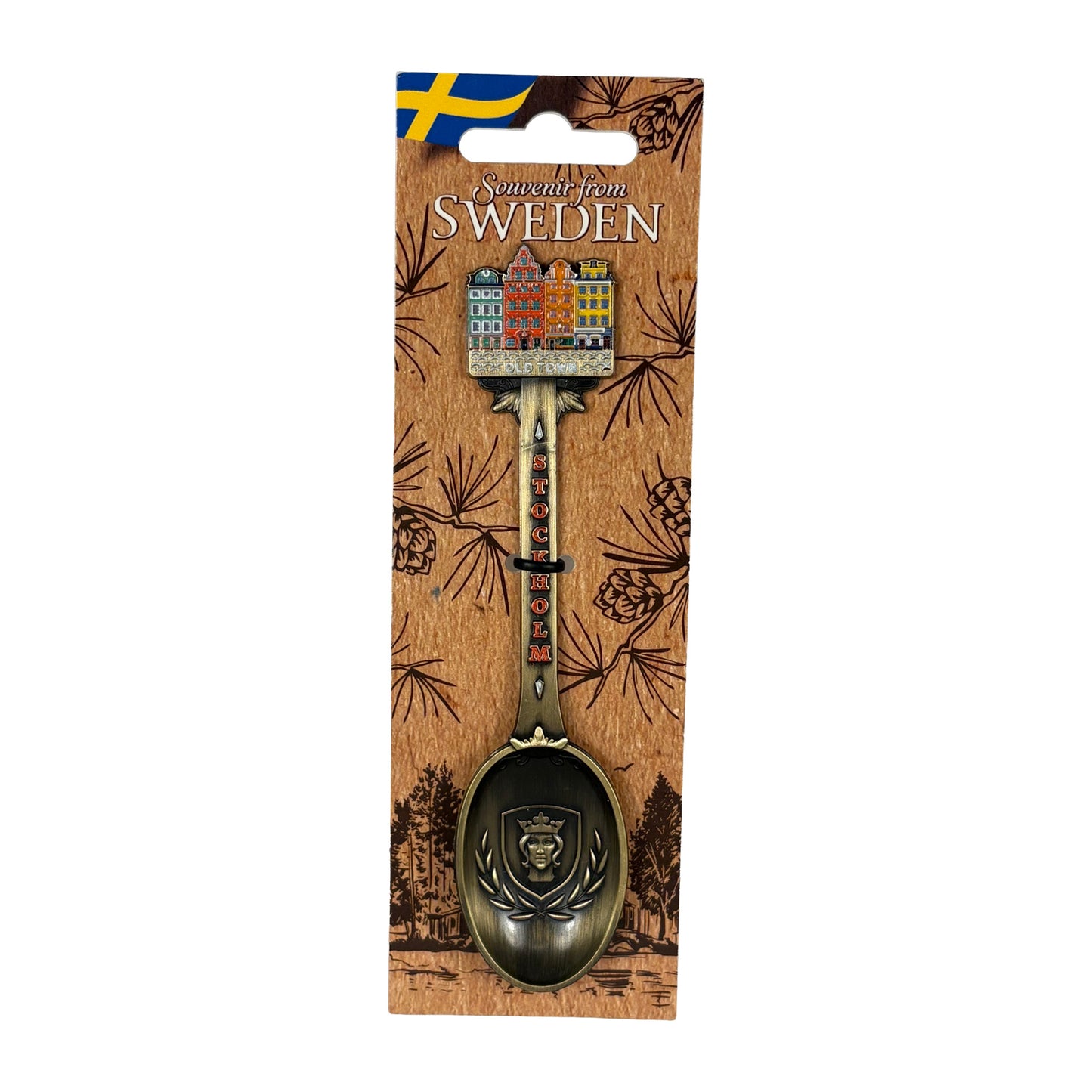 Bronsfärgad souvenirsked med Stockholms stadsvapen i skedbladet och Stortorget i Gamla Stan på skaftet, tillsammans med en ljusbrun hängetikett dekorerad med ett skogsmotiv, svensk flagga och texten ”Souvenir from Sweden".