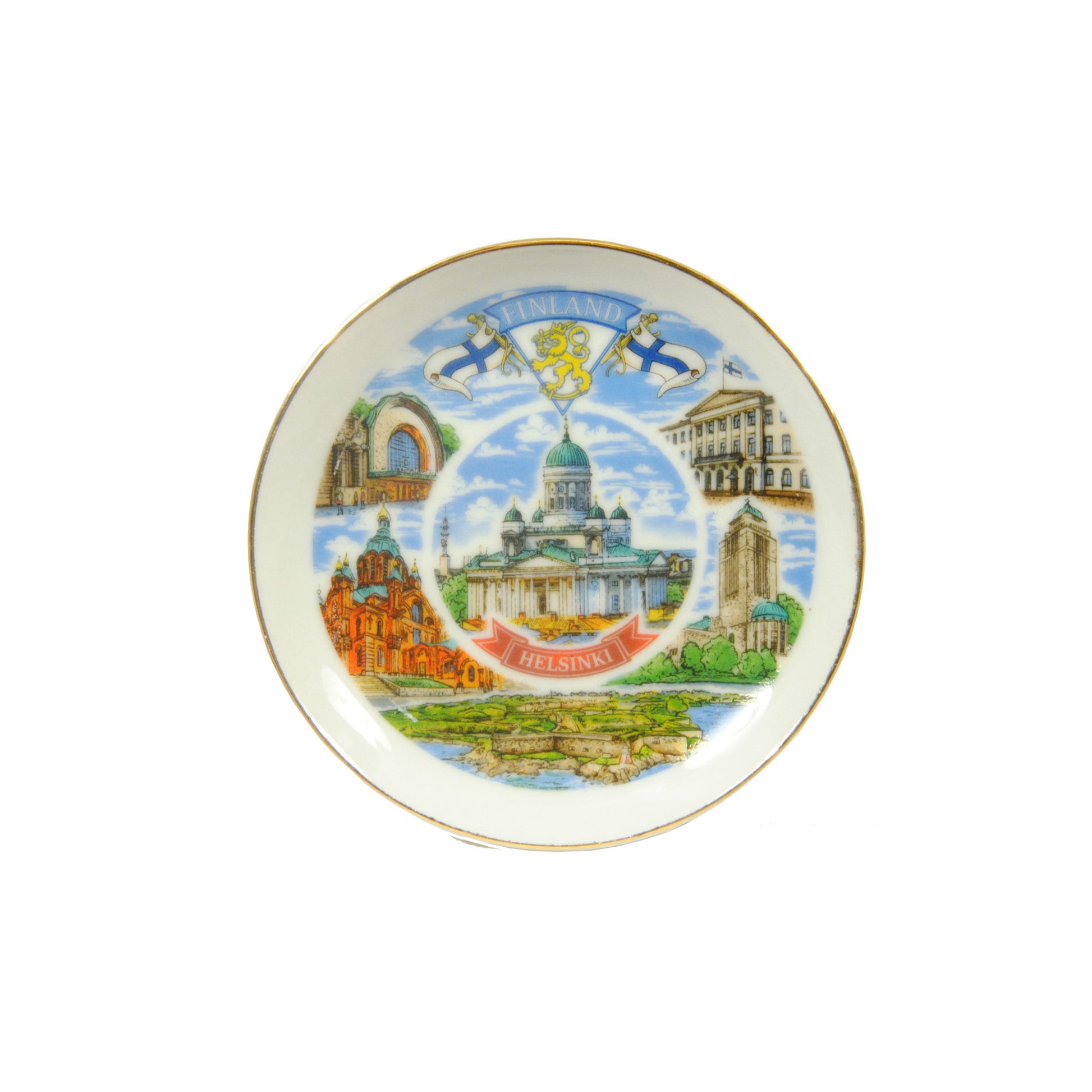 Mini souvenir­tallrik i porslin med guldkant och motiv av Helsingfors Domkyrka i mitten, omgiven av andra sevärdheter som Sveaborg. Diameter 10 cm.