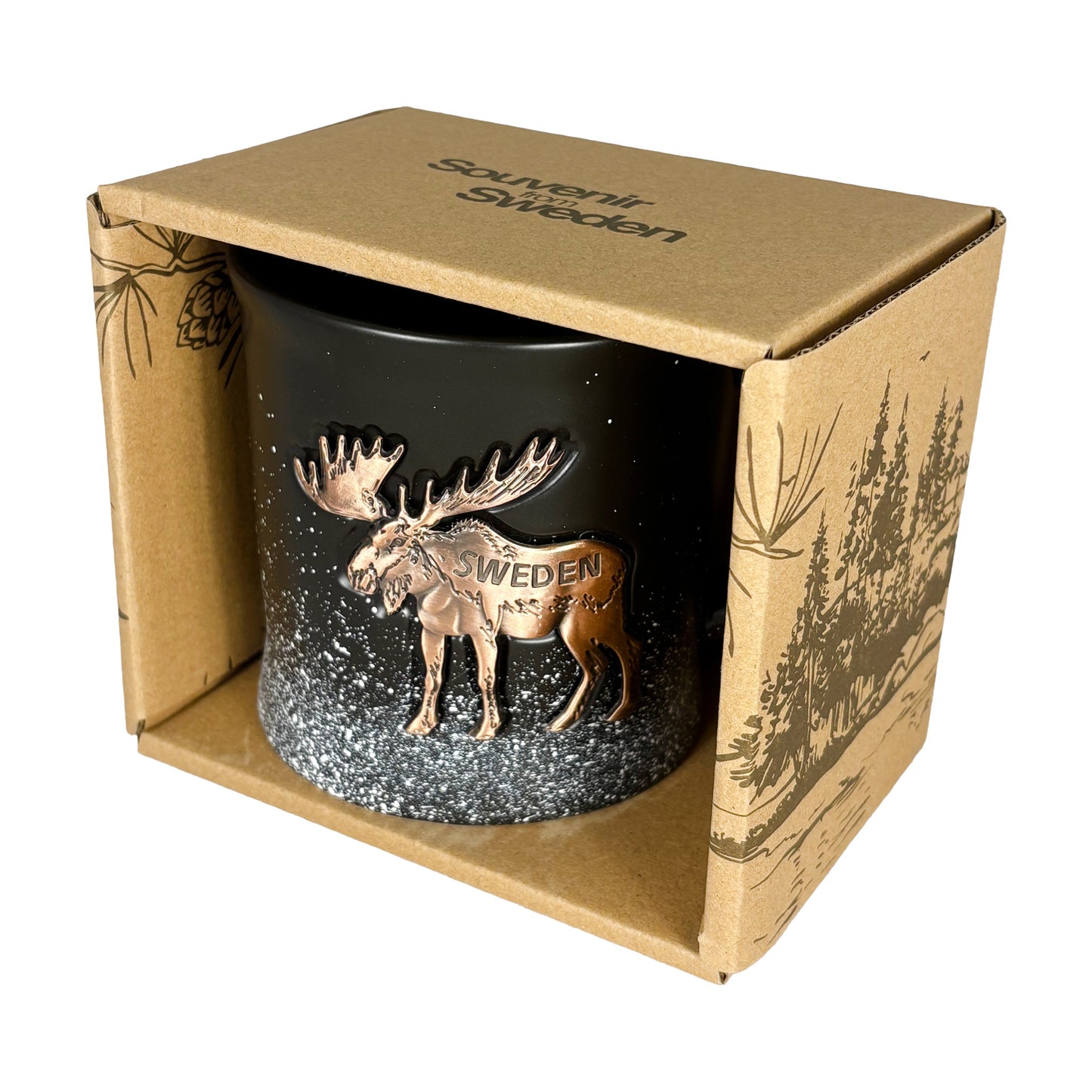 Svart mugg med bronsfärgad älg i en brun pappförpackning med mörkbrunt skogsmotiv och texten "Souvenir from Sweden" på toppen