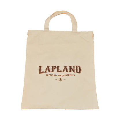 Baksida av tygkasse prydd med texten "Lapland Arctic Region of Extremes". Tygkassen är beige och texten är brun. 