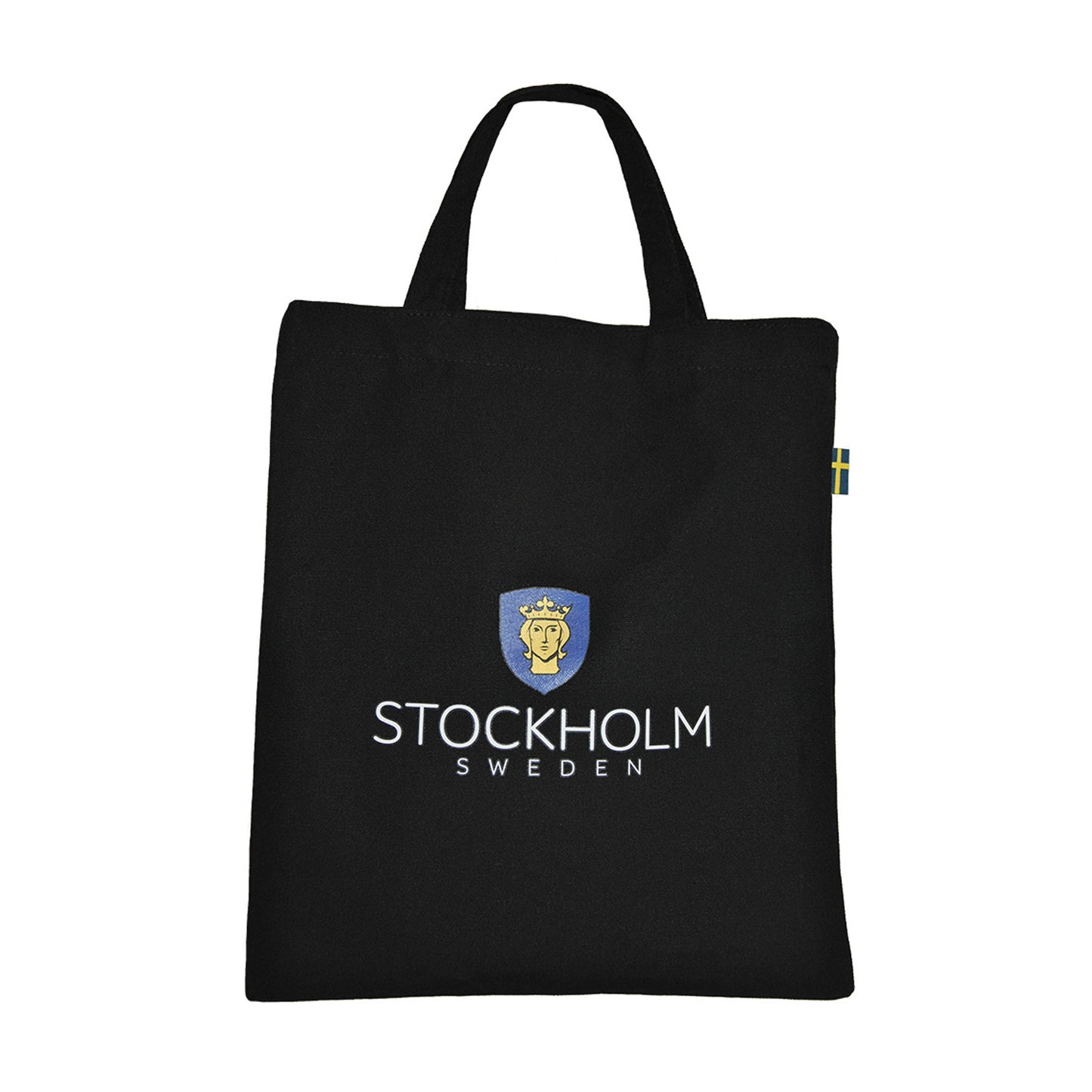 Baksida av svart tygkasse dekoerad med texten "STOCHOLM SWEDEN" och Stockholms stadsvapen. På ena kanten av väskan finns en liten svensk flagga fastsydd. 
