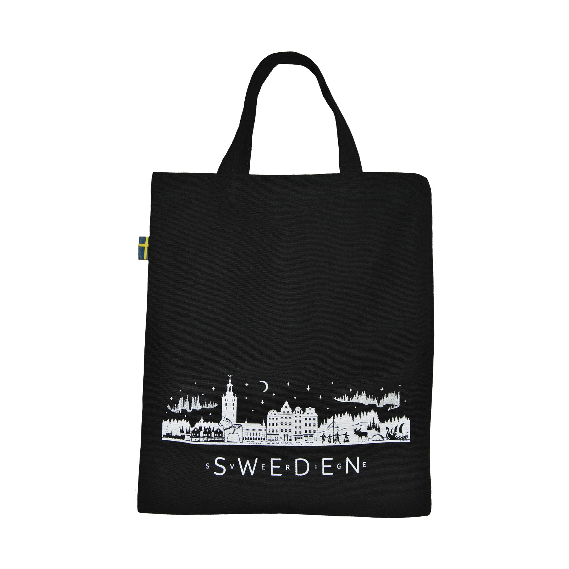Svart tygkasse med vit skyline som visar typiska svenska motiv, bland annat älg, midsommarstång, sjöbodar, Stockholms stadshus och vikingaskepp. Texten "Sweden" och "Sverige" pryder kassen, och kanten är dekorerad med den svenska flaggan.